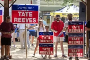 Gov. Tate Reeves supporters hold political signs during the 2023 Neshoba County Fair in Philadelphia, Miss., Thursday, July 27, 2023.